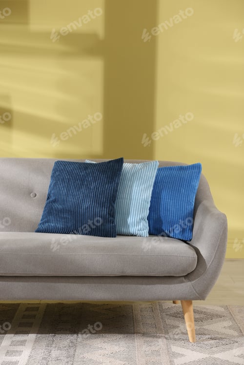 Preview: Soft pillows on grey sofa near green wall indoors