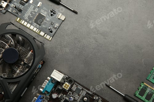 Preview: Graphics card and other computer hardware on grey textured table, flat lay. Space for text