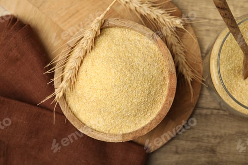 Preview: Raw semolina in bowl with spikes on wooden table, flat lay