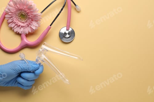Preview: Gynecology. Doctor with vaginal speculum, stethoscope and gerbera flower on beige background, top vi