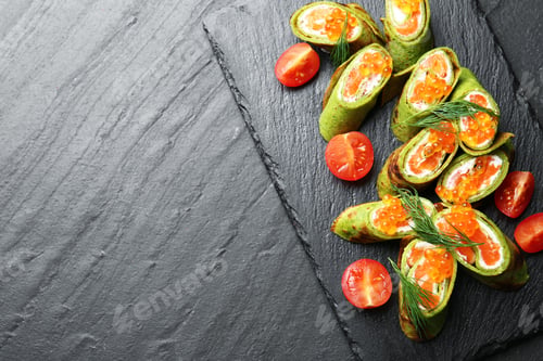 Preview: Tasty spinach crepes with salmon, cream cheese, red caviar, tomatoes and dill on black table, top vi