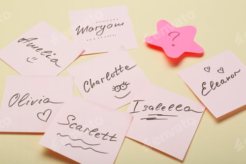Preview: Choosing baby name. Paper stickers with different names and question mark on beige background