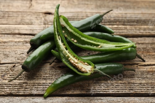Preview: Fresh green chili peppers on wooden table, closeup