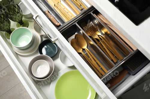 Preview: Ceramic dishware and cutlery in drawers indoors, above view