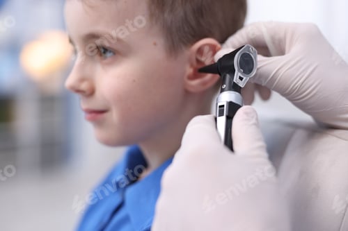 Preview: Hearing test. Doctor examining boy's ear with otoscope in clinic, closeup