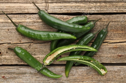 Preview: Fresh green chili peppers on wooden table, top view
