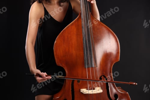 Preview: Woman playing double bass on black background, closeup
