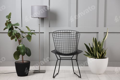 Preview: Stylish floor lamp, chair and houseplants indoors. Interior design