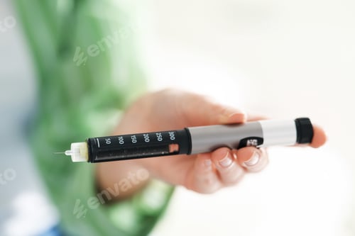 Preview: Diabetes. Woman with autoinjector at home, closeup