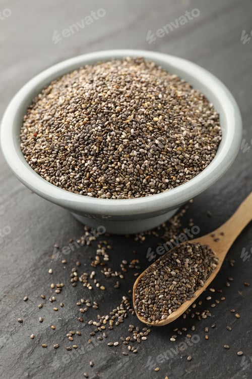 Preview: Natural chia seeds in bowl and spoon on grey textured table, closeup