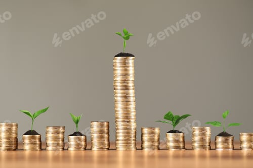 Preview: Savings concept. Stacked coins with sprouts on wooden table