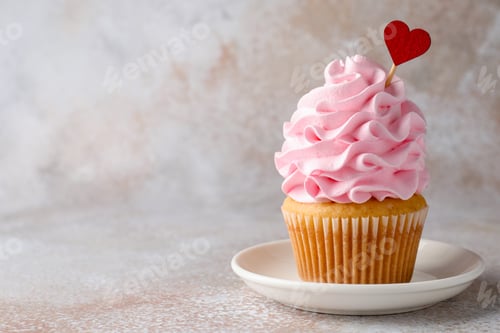 Preview: Happy Valentine's Day. Tasty cupcake with red heart topper on grey table, closeup. Space for text