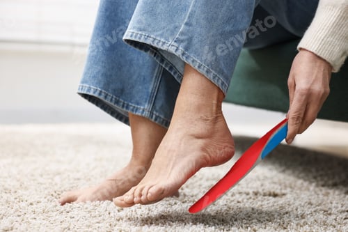 Preview: Senior woman fitting orthopedic insole at home, closeup