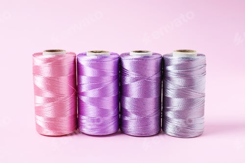 Preview: Spools of sewing threads on pink background