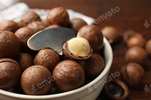 Preview: Macadamia nuts and metal key in bowl on table, closeup