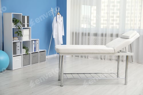 Preview: Examination table and other furniture in modern clinic. Interior design