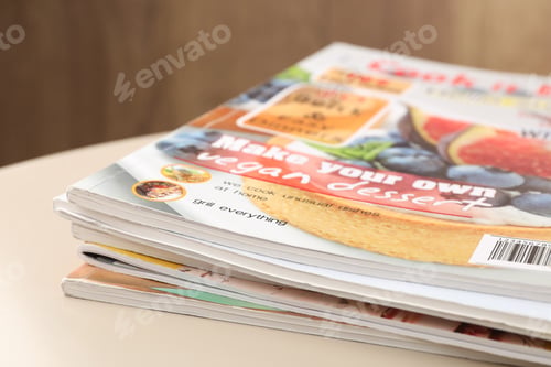 Preview: Stack of magazines on white table, closeup