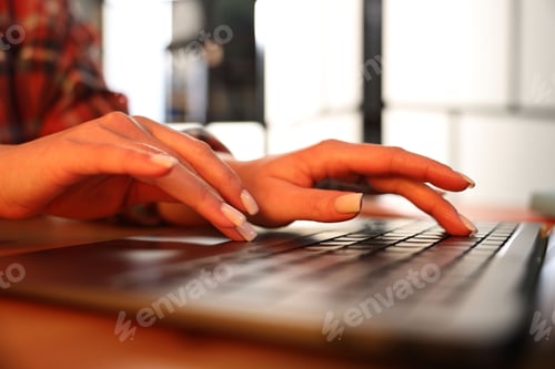 Preview: Woman working on laptop at desk indoors, closeup