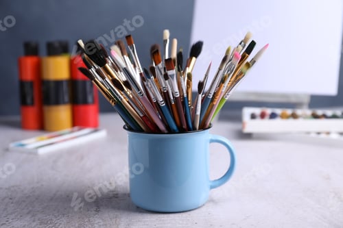 Preview: Paintbrushes in holder and paints on table