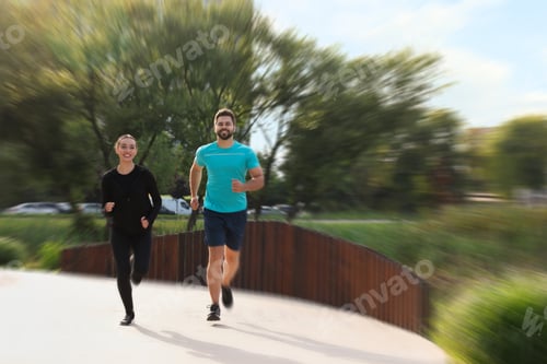 Preview: Woman and man in sportswear running outdoors, motion blur effect