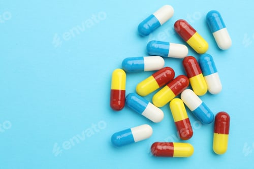 Preview: Pills on light blue background, flat lay. Space for text