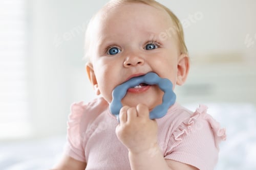 Preview: First baby teeth. Cute child with teether at home