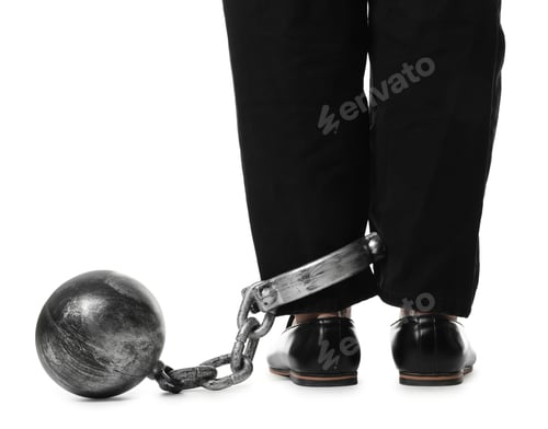 Preview: Businessman with metal ball and chain on his leg against white background, closeup
