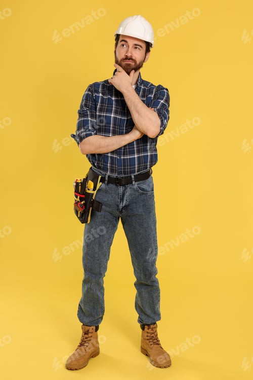 Preview: Professional builder with tool belt on yellow background