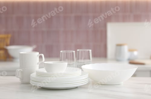 Preview: Clean dishes on white table in kitchen