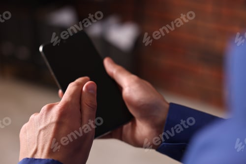 Preview: Man sending message via smartphone indoors, closeup. Space for text