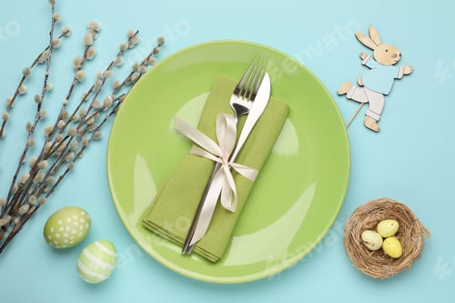 Preview: Easter celebration. Festive table setting with cutlery, willow branches and painted eggs on light bl