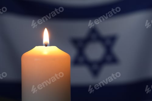 Preview: Holocaust Remembrance Day. Burning candle against flag of Israel, closeup. Space for text