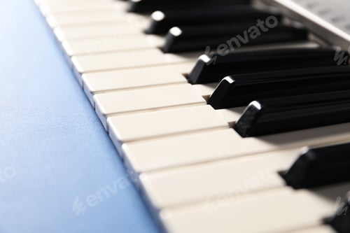 Preview: Piano keyboard on blue background, closeup. Musical instrument