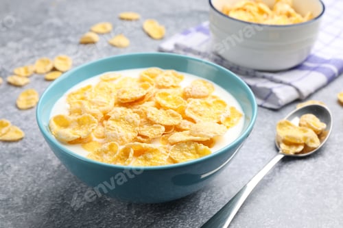 Preview: Tasty corn flakes with milk in bowl served on grey table, closeup