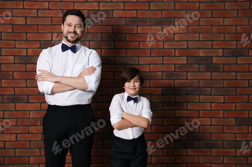 Preview: Father and son in formal outfits near brick wall. Space for text