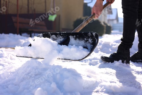 Preview: Man removing snow with shovel outdoors on winter day, closeup