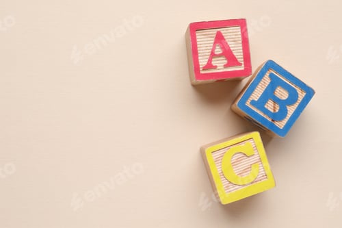 Preview: Wooden cubes with letters on beige background, flat lay. Space for text
