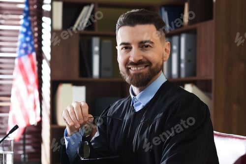 Preview: Portrait of smiling judge with glasses at table in office