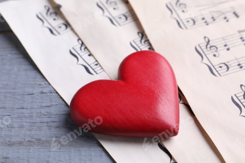 Preview: Heart figure and paper sheets with music notes on gray wooden table, closeup