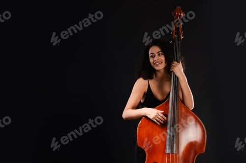 Preview: Woman with double bass on black background, space for text