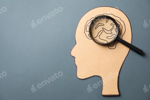 Preview: Amnesia. Human head cutout with drawing of brain and magnifying glass on grey background, top view.