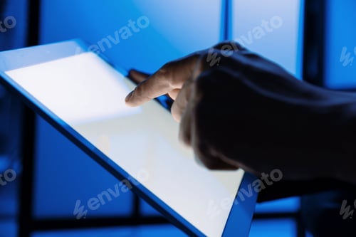 Preview: Man using modern tablet indoors, closeup view