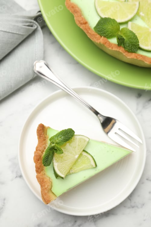 Preview: Delicious lime pie served on white marble table, flat lay