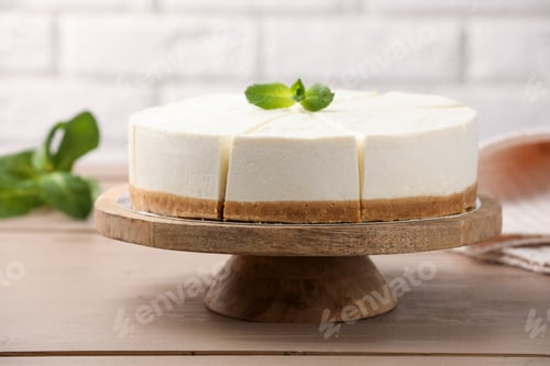 Preview: Tasty cut cheesecake with mint on wooden table, closeup