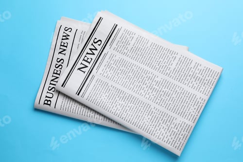 Preview: Folded newspapers on light blue background, top view