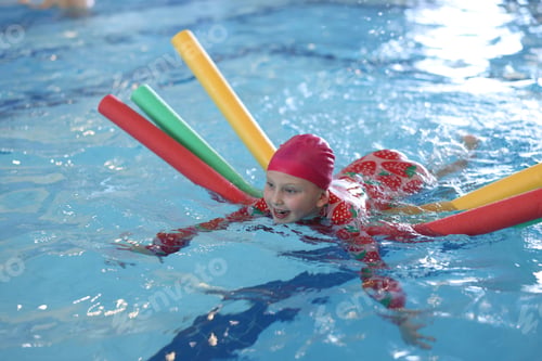 Preview: Cute little girl swimming with water noodles during lesson in pool