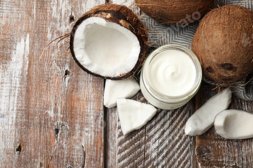 Preview: Delicious coconut yogurt in glass jar and fruits on wooden table, flat lay. Space for text