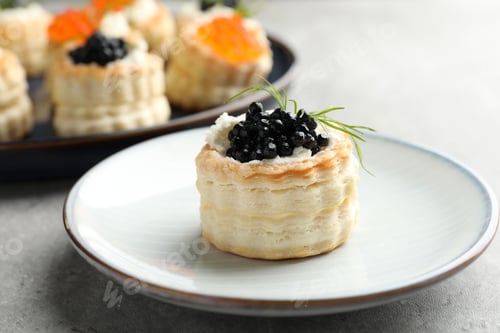 Preview: Tasty puff pastries with cream cheese, caviar and dill on grey table, closeup