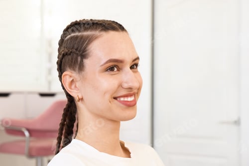 Preview: Smiling teenage girl with beautiful braids in salon. Space for text
