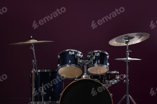 Preview: Modern drum kit on burgundy background, closeup. Musical instrument